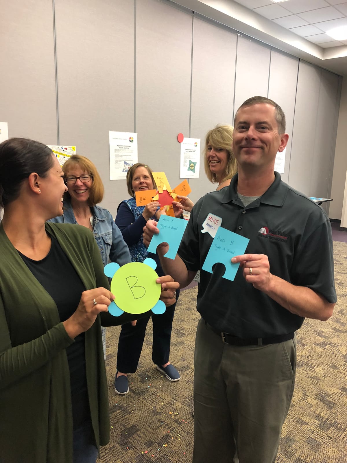 Two participants smiling and holding up matching puzzle pieces